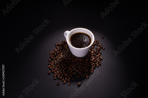 A full cup of coffee and coffee beans are lit around the top.