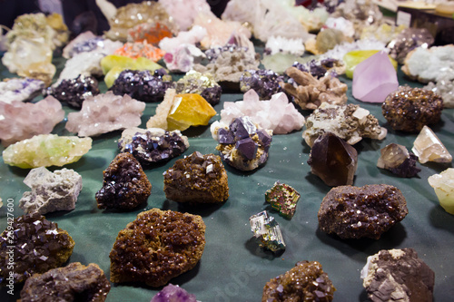 Fototapeta Naklejka Na Ścianę i Meble -  Raw fragments of different precious and semiprecious stones and gems chaotically scattered on the table