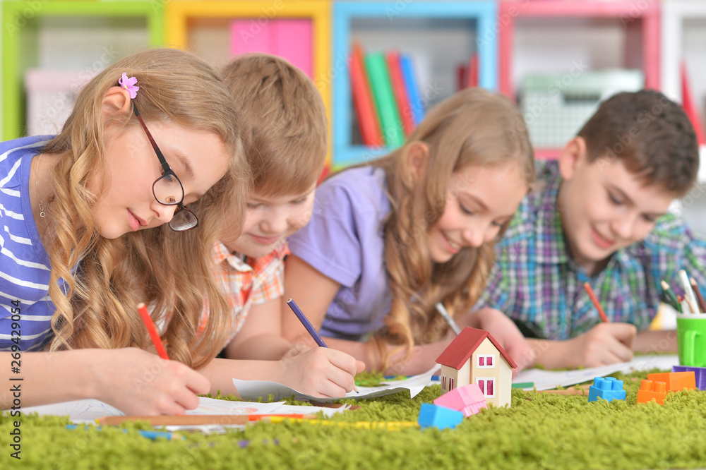 Portrait of group of children drawing with pencils