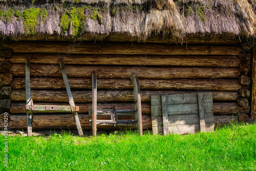 old agricultural equipment on rustic log wall