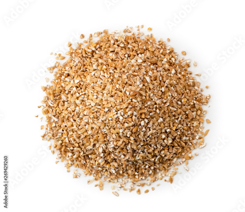 Heap of dry wheat groats on a white background. The form of the top.