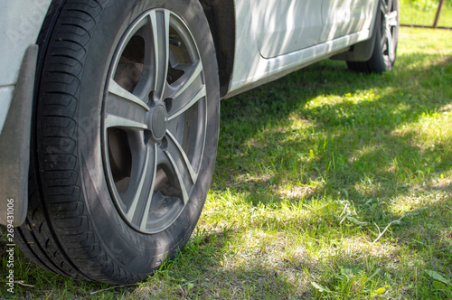 The car is parked on a green grass with violation of the rules of the parking.