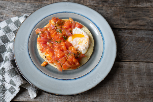 Mexican food: Fried egg rancheros with sauce and corn tortilla