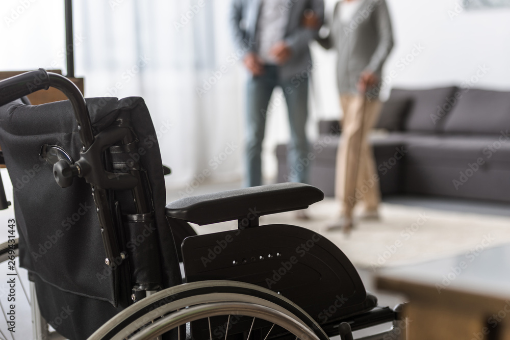 Obraz premium selective focus of adult son and senior mother with wheelchair on foreground