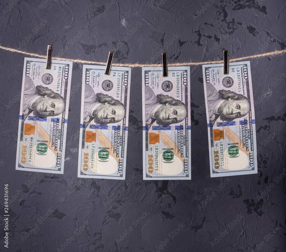 Fototapeta premium Money Laundering. Money Laundering US dollars hung out to dry. 100 dollar bills hanging on clotheslines