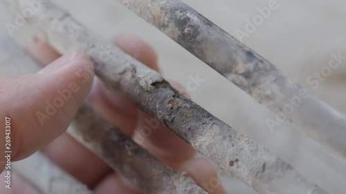 Burnt-out heating element from a washing machine. Man is touching turbular electric heating element covered with limescale. photo