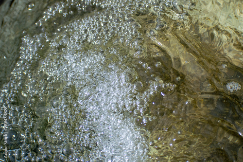 Bubbling water flows from the pipe with bubbles.
