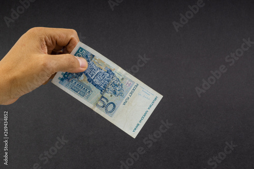 Hand holding fifty Croatian KUNA or STO KUNA bank notes on black background. Financial concept and selective focus