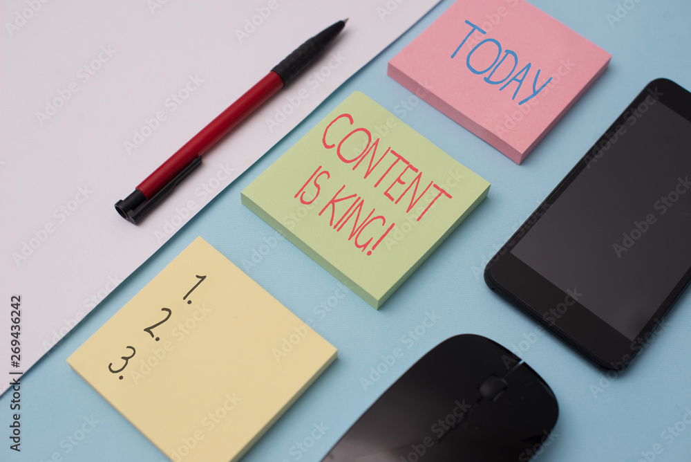Writing note showing Content Is King. Business concept for marketing focused growing visibility non paid search results Note papers and stationary plus gadgets placed sideways above backdrop