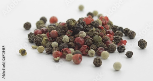 Mix of multicolored pepper. Peas with spices. Macro on white background