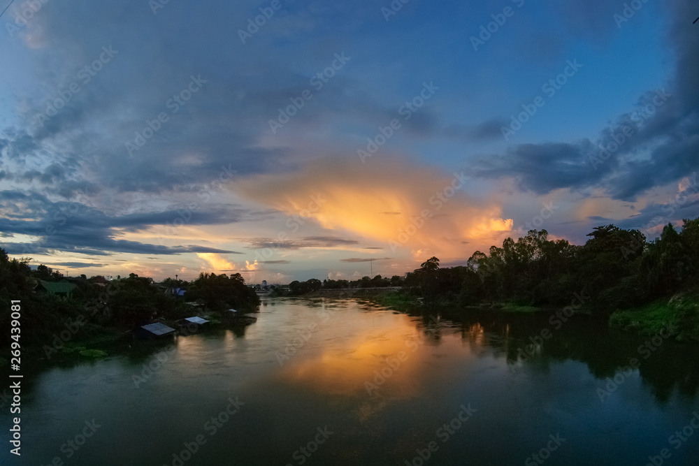 sunset at Mae Klong river, view of soft sun light above the river with cloudy sky background, Ban Pong District, Ratchaburi, Thailand.