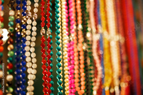 Colorful jewelry beads on the Indian night market, hang on the counter of Goa, India