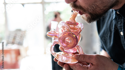 Photos glass bong close-up in mans hands in process