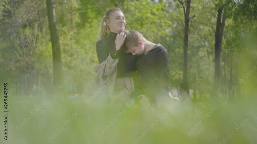 Portrait young mother and her teen son resting in the park together. Happy friendly family. Adorable boy hugs his beautiful mom. Leisure outdoors. Portrait young mother and her teen son resting in the park together. Happy friendly family. Adorable boy hugs his beautiful mom. Leisure outdoors.