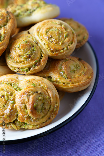 Pistachio roll buns served in a white plate with black rim. Violet linen napkin, high resolution