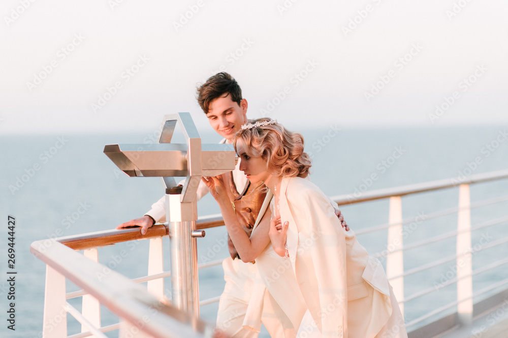 Obraz premium Young beautiful couple on the deck of a cruise liner in the sea