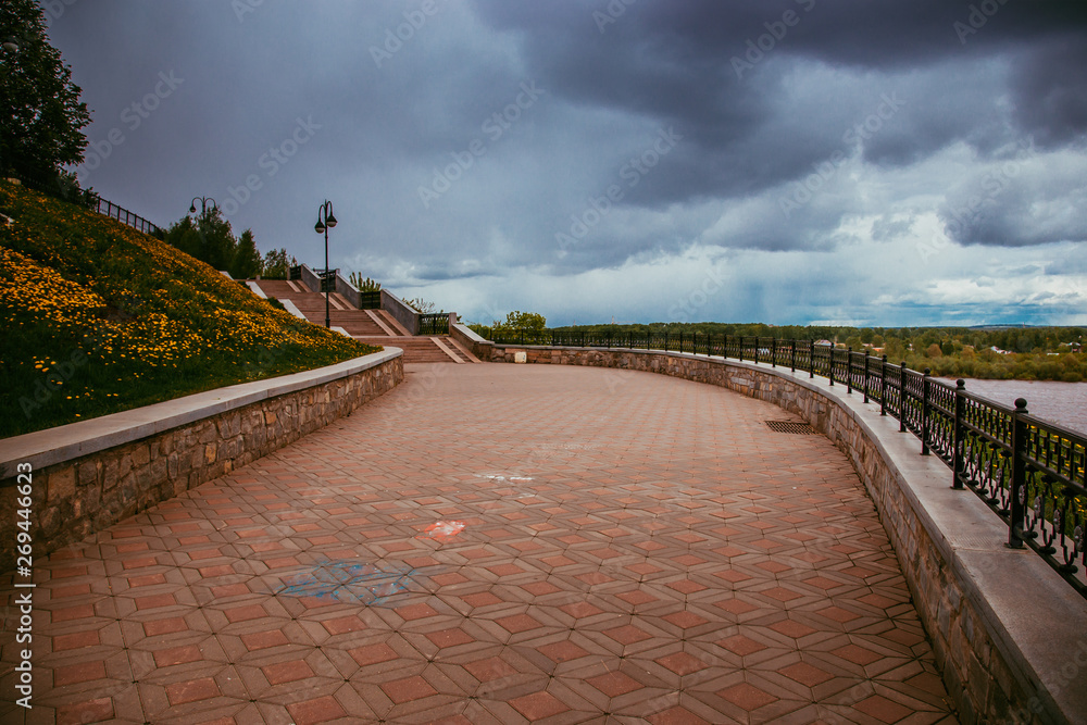 Fototapeta premium deserted city embankment on a cloudy summer day