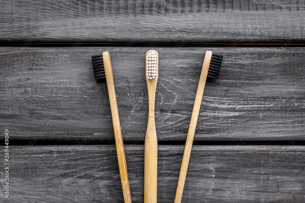 Eco materials concept with bamboo tooth brush on wooden background top view Eco materials concept with bamboo tooth brush on wooden background top view