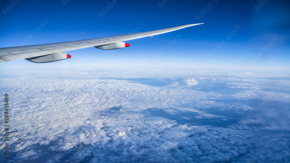 Close up of window with airplane wing. Beautiful cloudscape with clear blue sky. Close up of window with airplane wing. Beautiful cloudscape with clear blue sky.