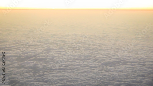 Aerial traveling. Flying at dusk or dawn. Fly through orange cloud and sun.