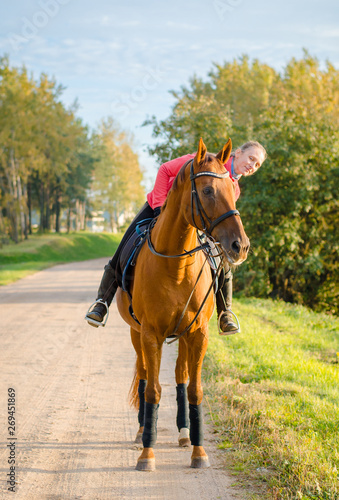 young woman and dressage horse in autumn