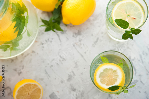 Homemade refreshing lemonade in decanter close-up and copy space. Lemonade from lemons, mint, ice.