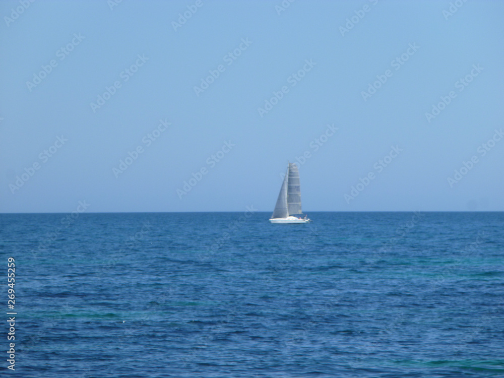 sailboat sailing in the mediterranean sea on the horizon