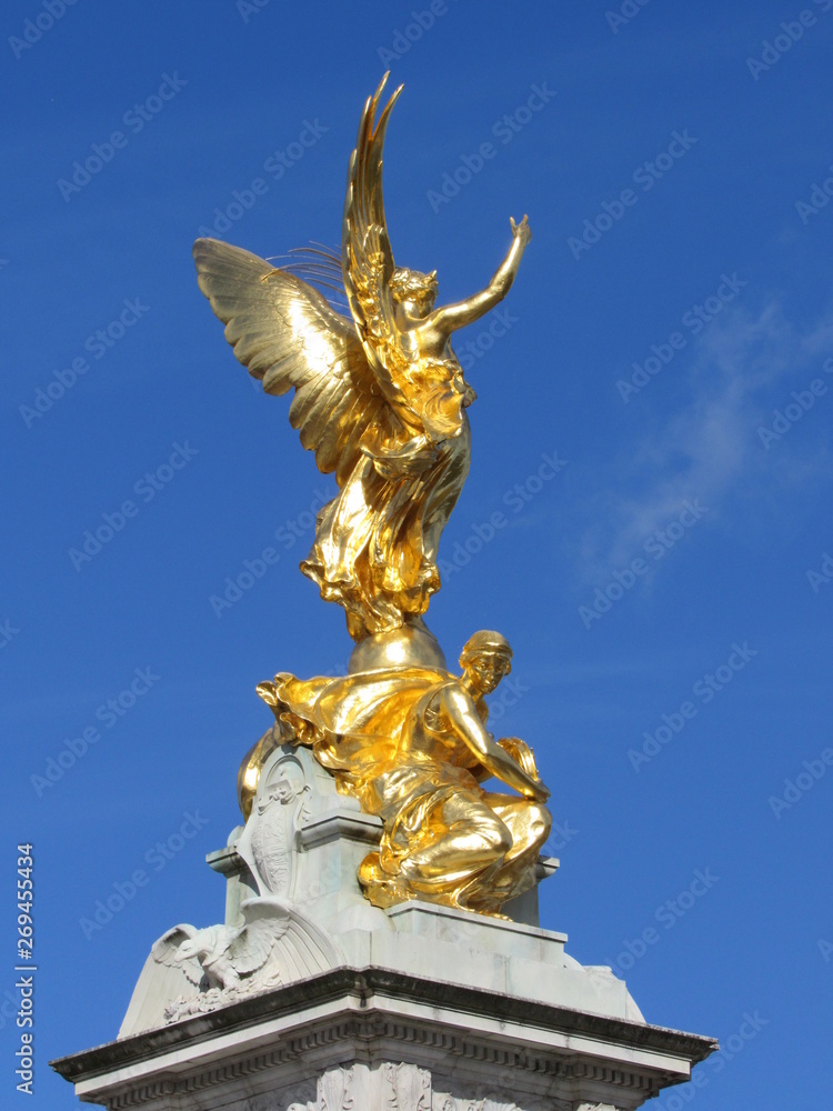 View of the Queen Victoria Memorial located in front of Buckingham Palace with blue sky in the background