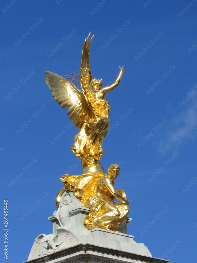Fototapeta premium View of the Queen Victoria Memorial located in front of Buckingham Palace with blue sky in the background