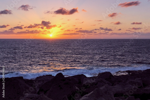 beautiful sunset in warm orange at the rocky coast of Playa Blanca, Lanzarote
