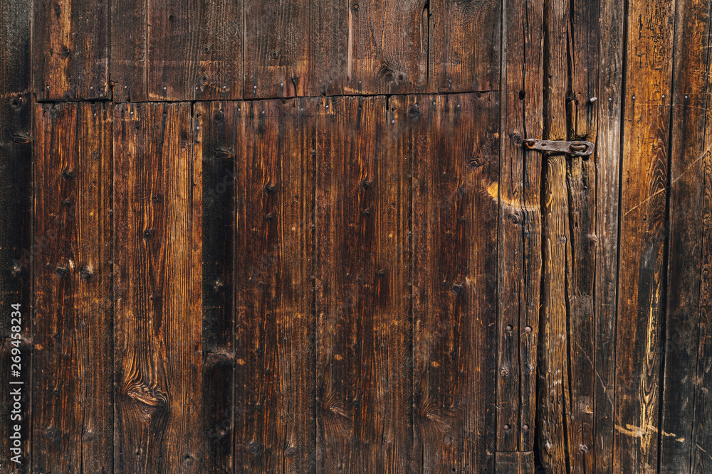 Very old wooden door of a warehouse or a barn. Big old gate made of