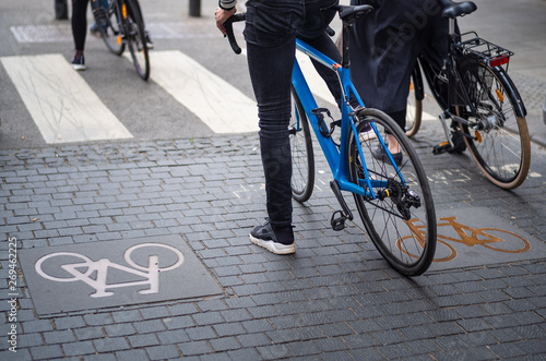 Canvas Print Young cyclists waiting for green light in a cycle symbol marked lane in Oslo, Norway