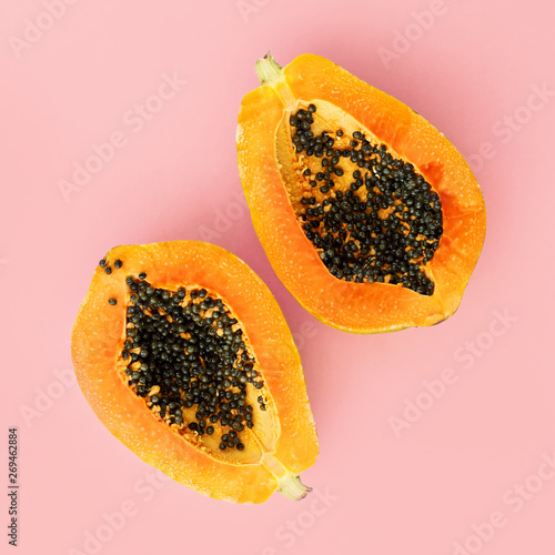 Half cut papaya on color background