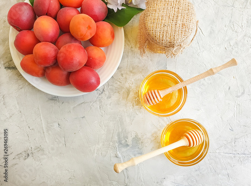 fresh peach on a plate, honey, iris flower on a gray concrete background photo