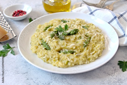 Italian risotto with spring asparagus and parmesan cheese on light background. Top view with copy space.