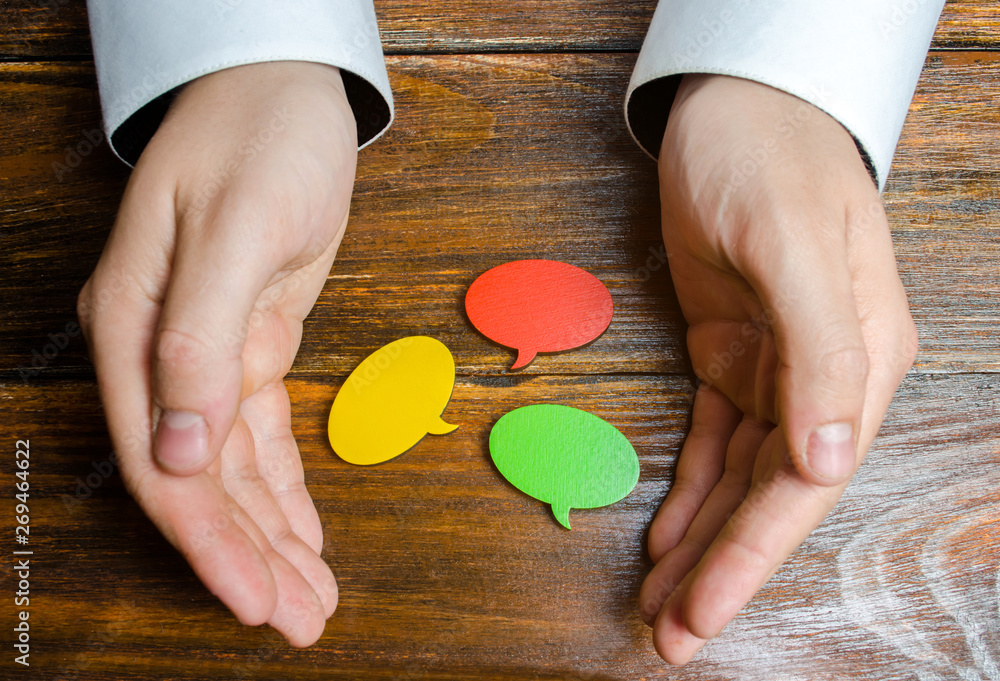 Φωτογραφία A man collects multicolored speech bubbles in his hands
