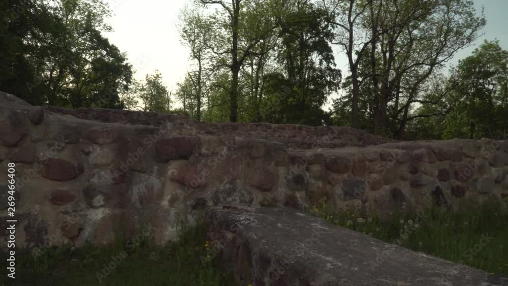 Foundations of old castle stone wall. 13th century Livonia Order castle ruins territory in the old town Dobele, Latvia. Summer of 2019. Foundations of old castle stone wall. 13th century Livonia Order castle ruins territory in the old town Dobele, Latvia. Summer of 2019.