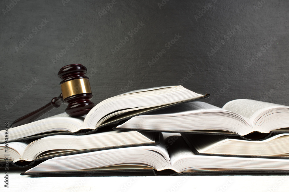 Law concept - Open law book with a wooden judges gavel on table in a courtroom or law enforcement office isolated on white table. Copy space for text. Law concept - Open law book with a wooden judges gavel on table in a courtroom or law enforcement office isolated on white table. Copy space for text.