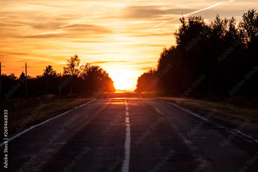 View on empty road leading off the horizon and beautiful sunset right above the roadway View on empty road leading off the horizon and beautiful sunset right above the roadway