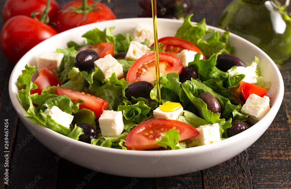 Greek Salad with Olives Tomatos and Feta Cheese on a Rustic Wood Table