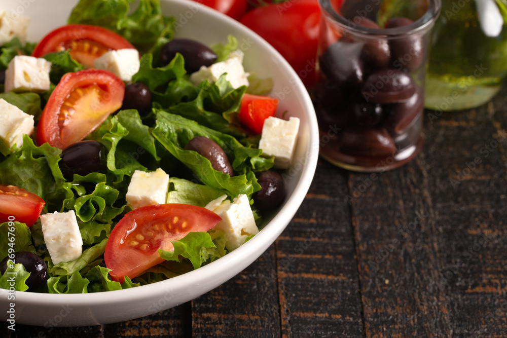 Greek Salad with Olives Tomatos and Feta Cheese on a Rustic Wood Table Greek Salad with Olives Tomatos and Feta Cheese on a Rustic Wood Table