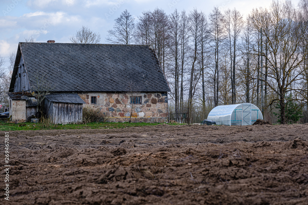 fresh cultivated fields with dark soil near forest in countryside fresh cultivated fields with dark soil near forest in countryside