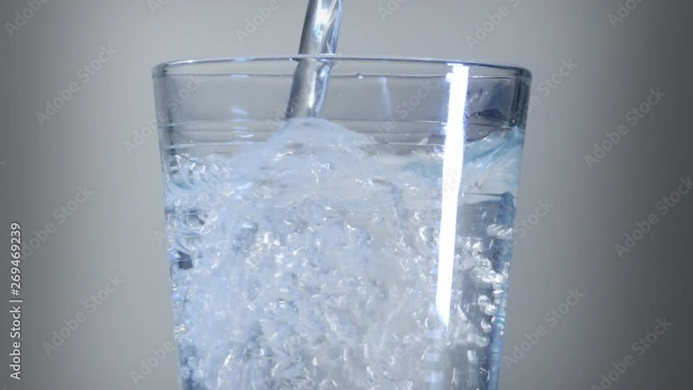 Falling water in a glass. Display of water falling in to a glass close-up Falling water in a glass. Display of water falling in to a glass close-up