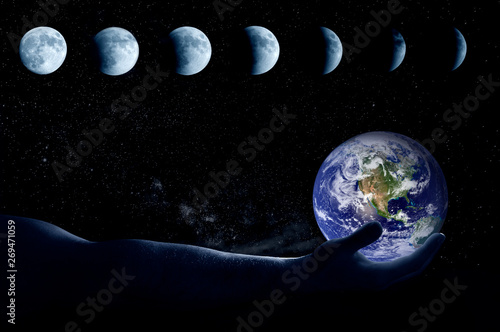 Fototapeta Naklejka Na Ścianę i Meble -  The hand holds the globe in the background all phases of the moon.