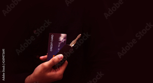 The young man paid the car debt by paying with a credit card with a car key in his hand.