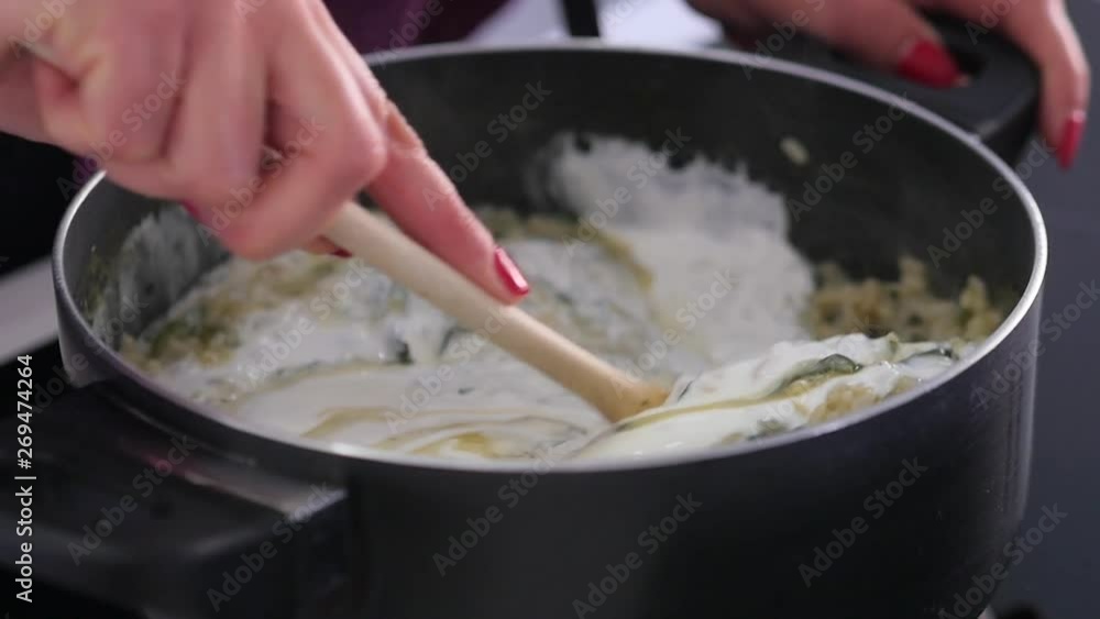 Close-up of stirring cream into a risotto while cooking Close-up of stirring cream into a risotto while cooking