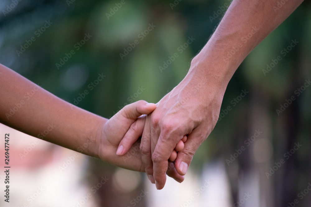 Close up of father and a child hands at the sunset with copy space. Love concept or family concept. Close up of father and a child hands at the sunset with copy space. Love concept or family concept.