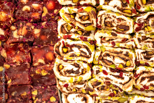 Turkish delight lined up on the workbench. White and red colors. There's peanuts, nuts, walnuts. photo