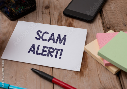 Word writing text Scam Alert. Business photo showcasing fraudulently obtain money from victim by persuading him Top view wooden table stationary paper tablet pen colored stick pad notes