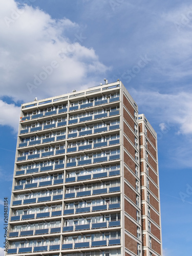 Tower social housing building against blue sky with clouds